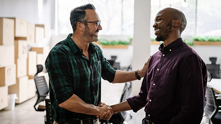 Small business owner shakes hands with excited new hire